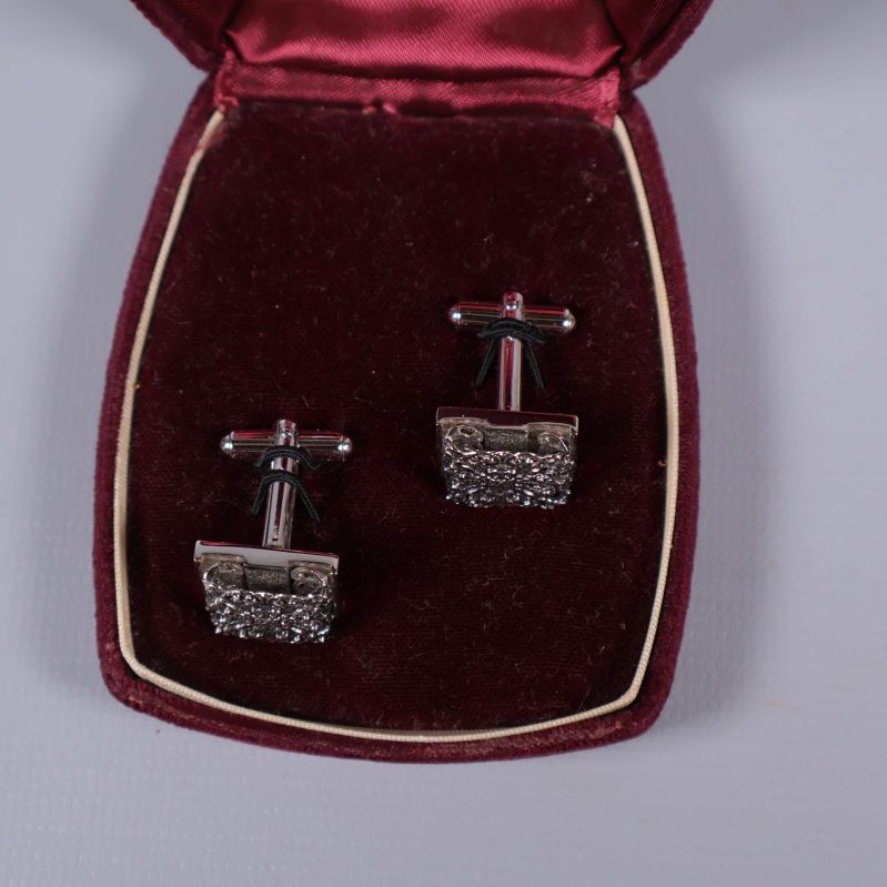 Manchettknappar visas bakifrån i öppen ask