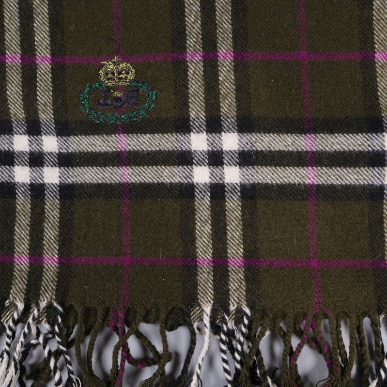 Närbild på rutigt mönster och broderat emblem