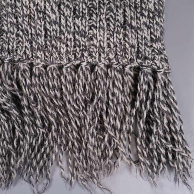 Närbild på tvinnade fransar på halsduk