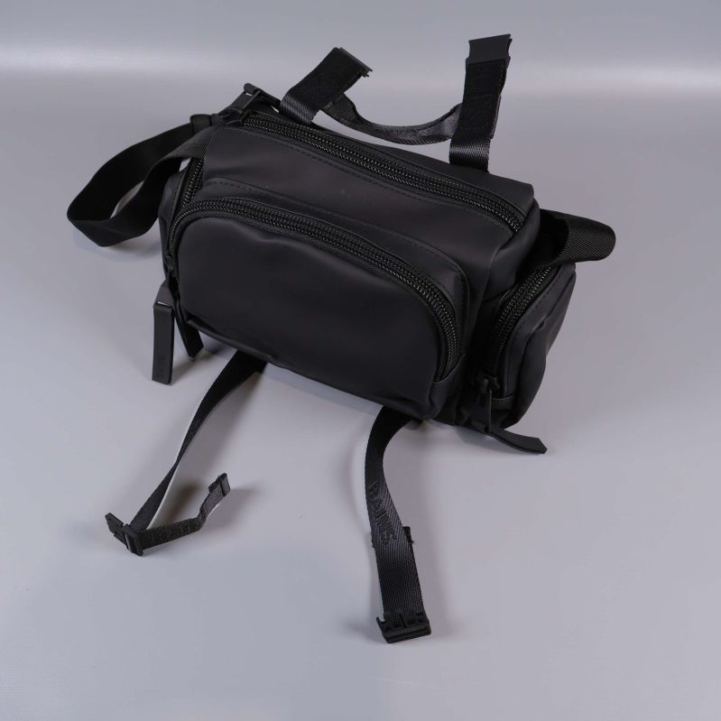 Svart väska med öppna fack och lösa remmar ovanpå