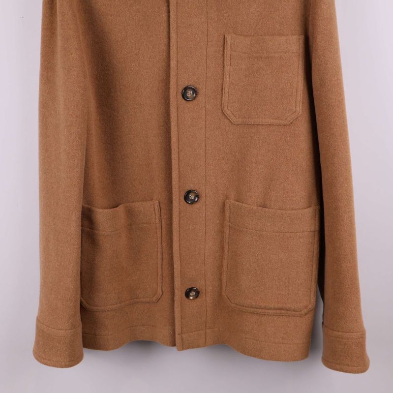 Nedre delen av kavaj visar två stora utanpåfickor och knappslå