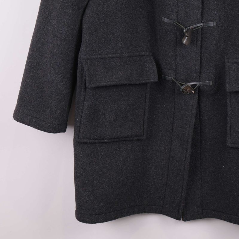 Närbild på framfickor på mörkgrå duffeljacka