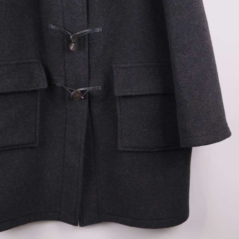 Detaljerad bild på nederkant och fickor på duffeljacka