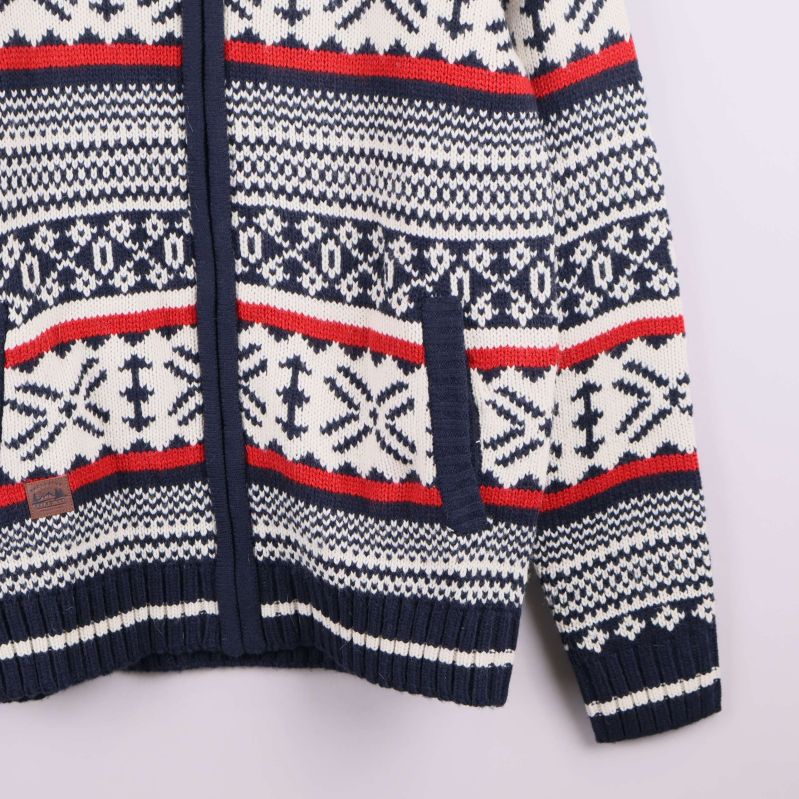 Stickad ficka med mönster och etikett syns på tröjan