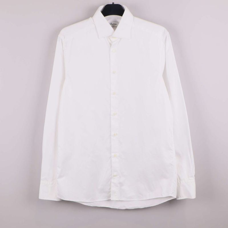 Vit skjorta med lång ärm upphängd mot ljus bakgrund