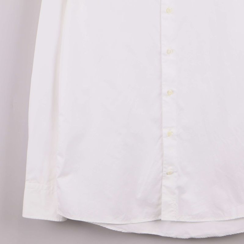 Nedre del av vit skjorta med synliga knappar