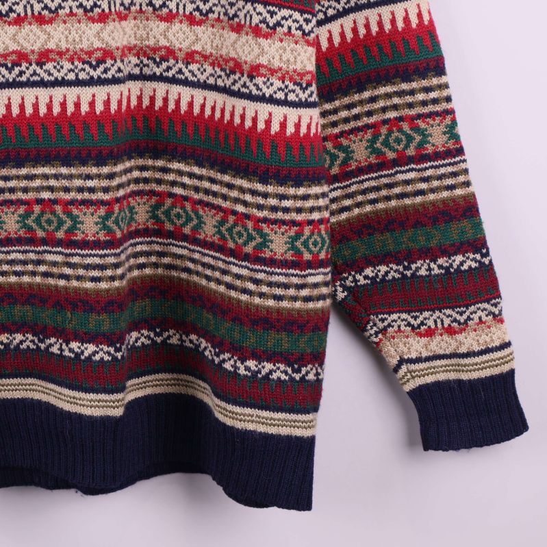 Nederdel av tröja med blå ärmmudd och mönsterdetaljer