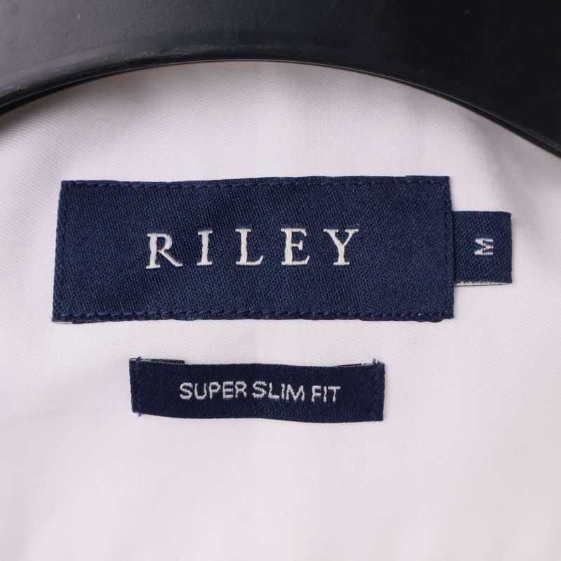 Närbild av Riley-märke och passformsinformation i skjortkragen