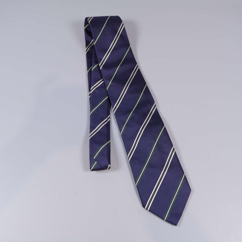 Mörkblå slips med vita och gröna diagonala ränder utlagd