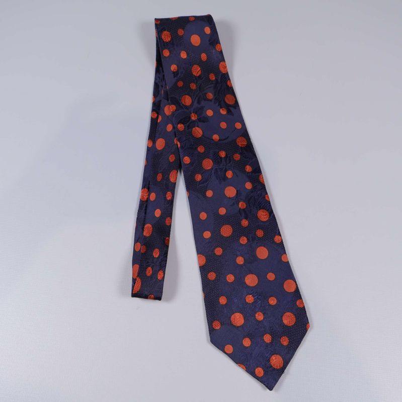 Prickig slips i mörkblått och orange utlagd på bord