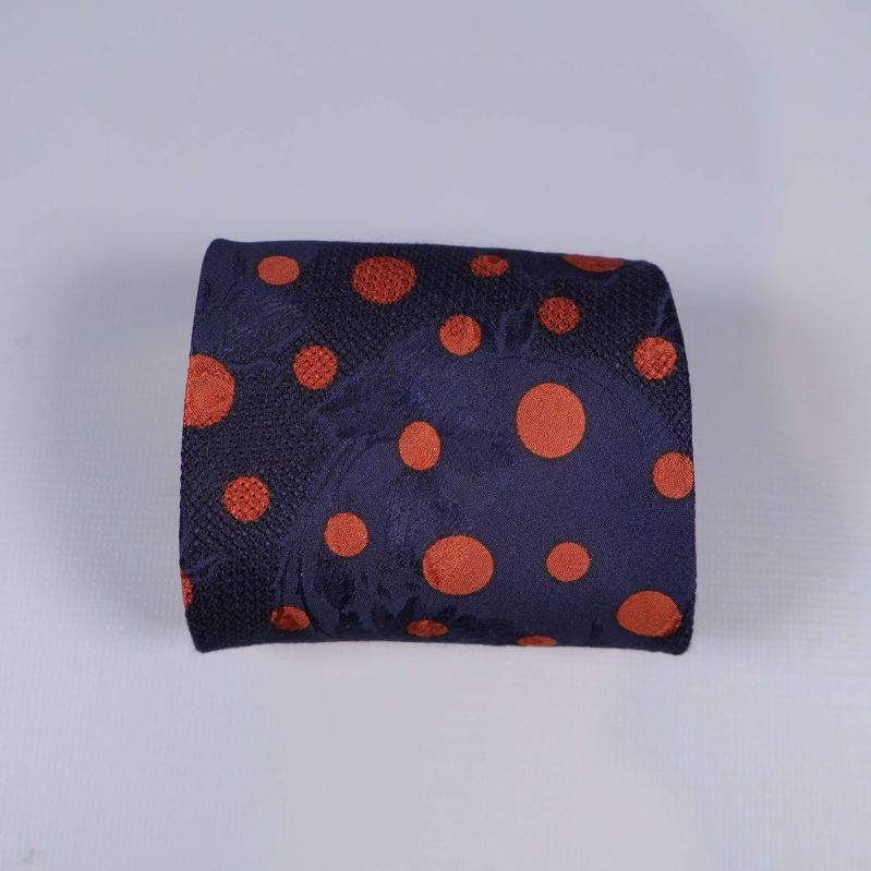 Sammanrullad slips med blå bakgrund och oranga prickar