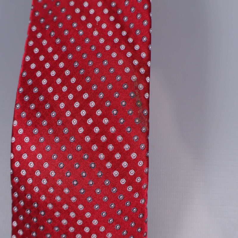 Närbild på den röda slipsspetsen med små vita prickar