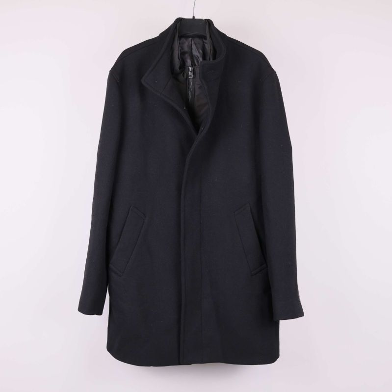 Svart kappa med rak passform upphängd på galge