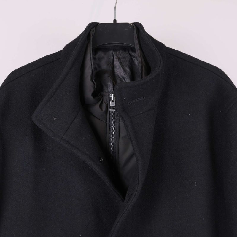 Närbild på ståkrage och dold dragkedja på kappa