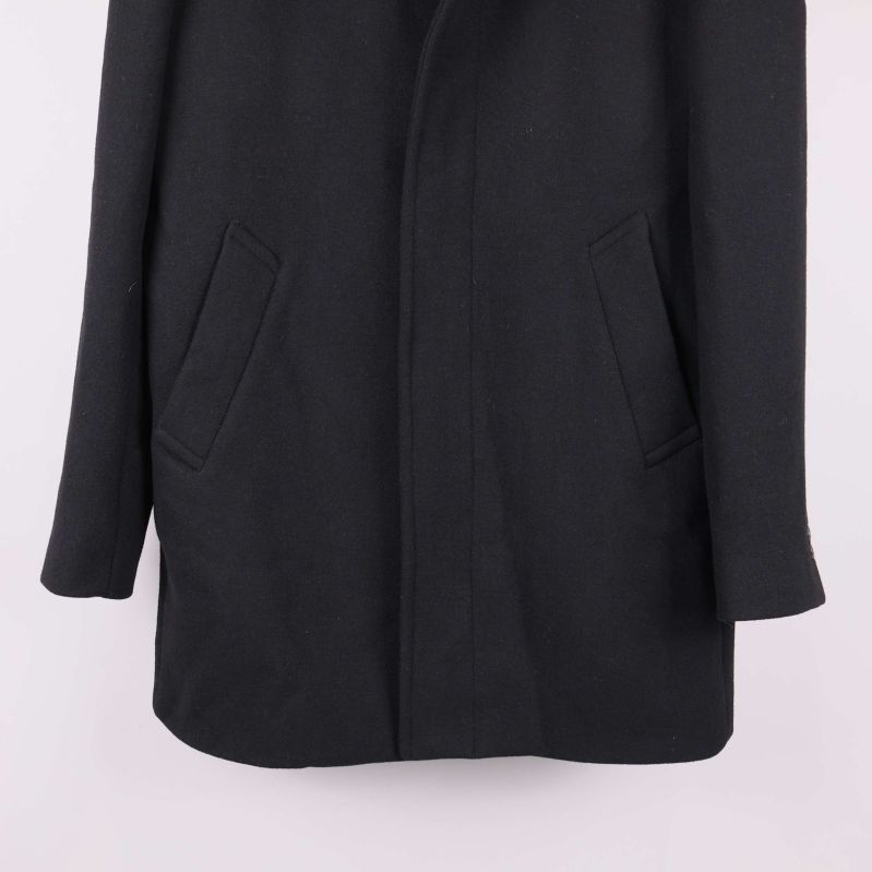 Nedre delen av svart kappa med två snedställda fickor