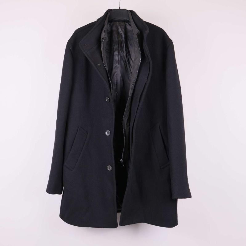Svart kappa uppknäppt så innerfodret syns tydligt