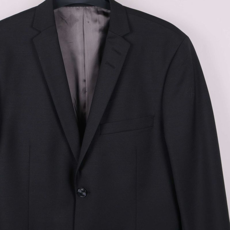 Närbild av överdelen på svart kavaj och slag