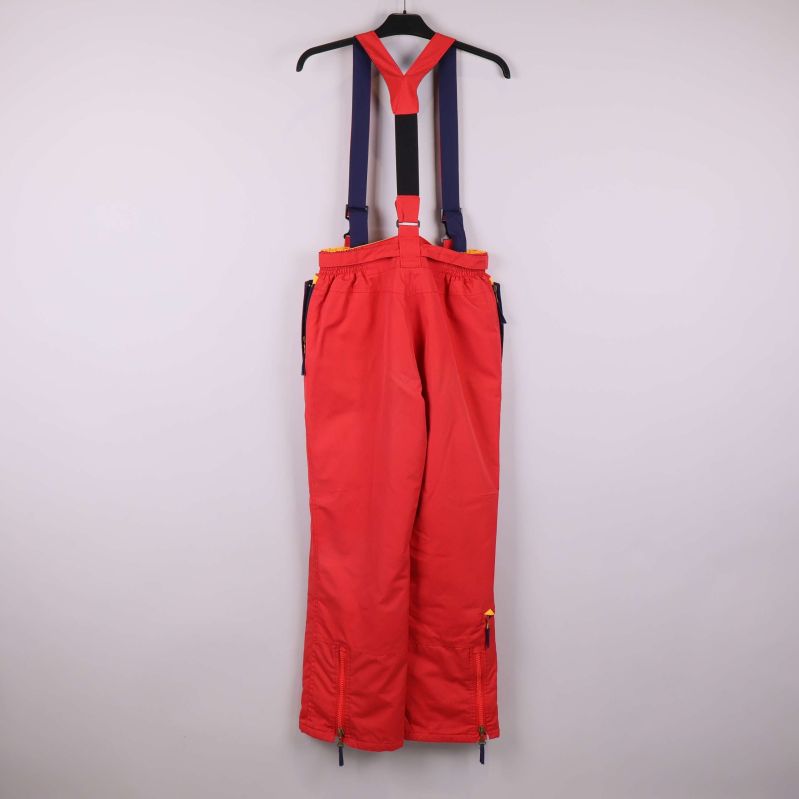 Baksidan av röda skidbyxor med blå och röda hängslen