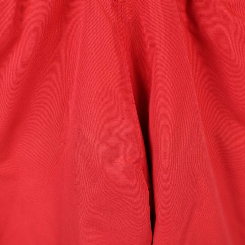 Materialdetalj på röda skidbyxor i närbild