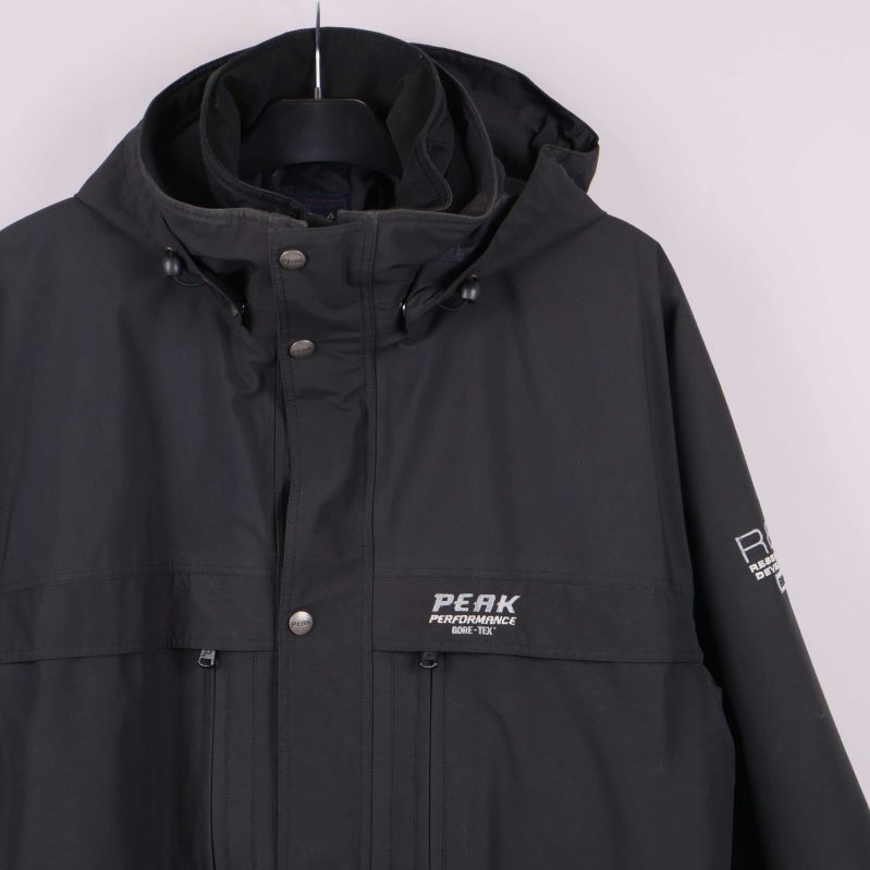 Närbild på logga och detaljer vid bröstet på svart jacka