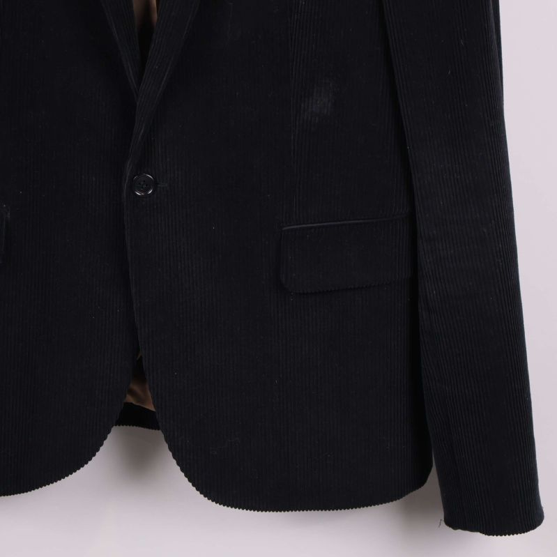 Närbild på kavajens nedre framstycke och manschett