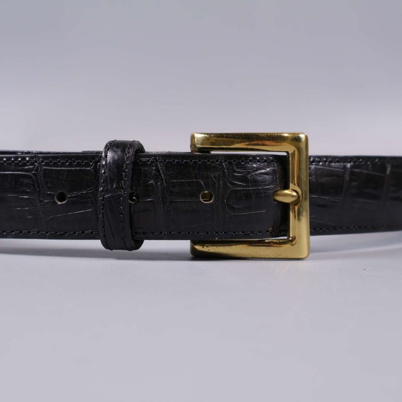 Närbild på bältets krokopräglade läder och spännet