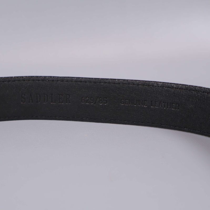 Stansad text med Saddler och genuine leather på insidan