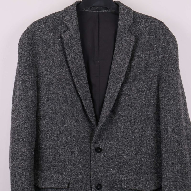 Närbild på kavajen med två knappar och fickor fram