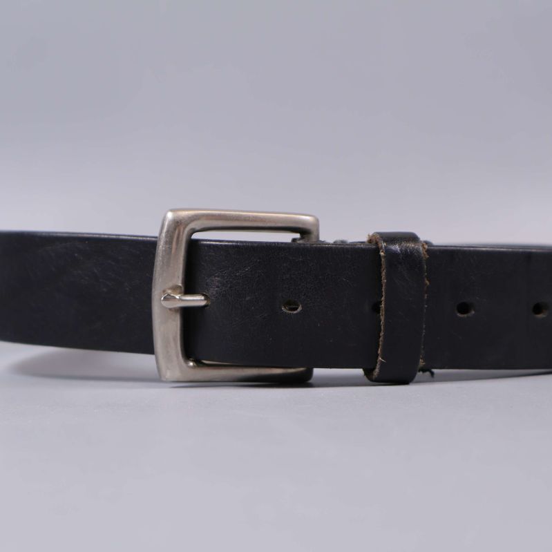 Närbild på bältesspänne och läderrem i svart