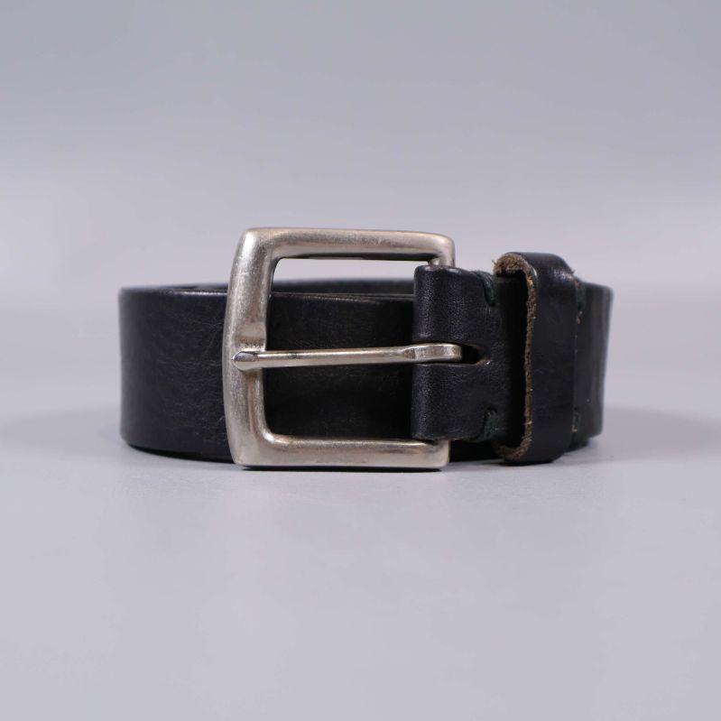 Framifrån vy av svart bälte rullat med spännet i fokus