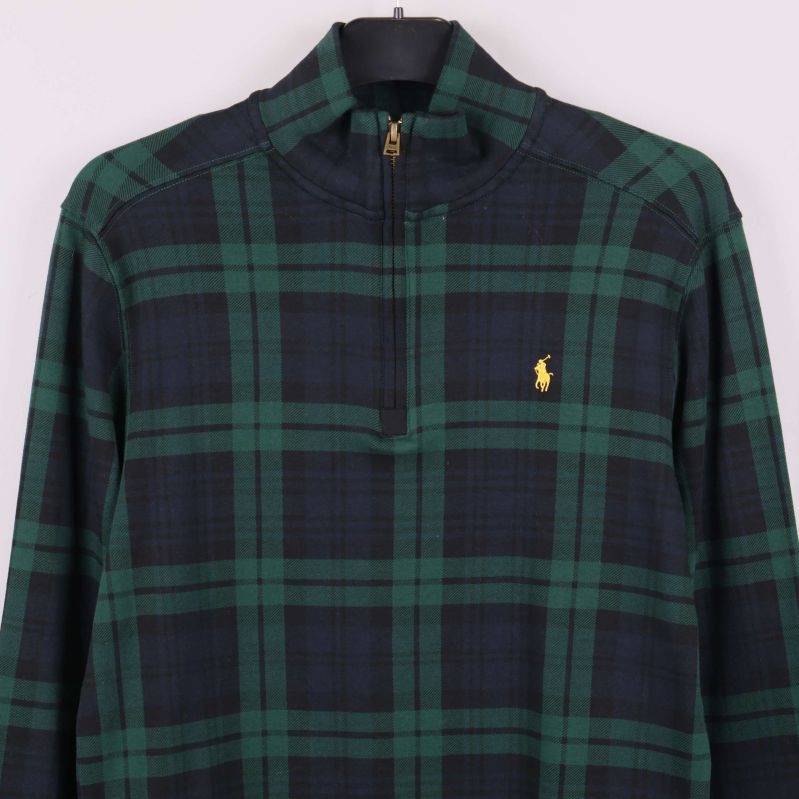 Detaljer på bröst och axlar med broderad gul logga