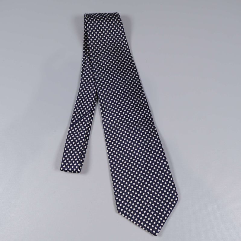 Helbild av mörkblå slips med rutmönster i vitt