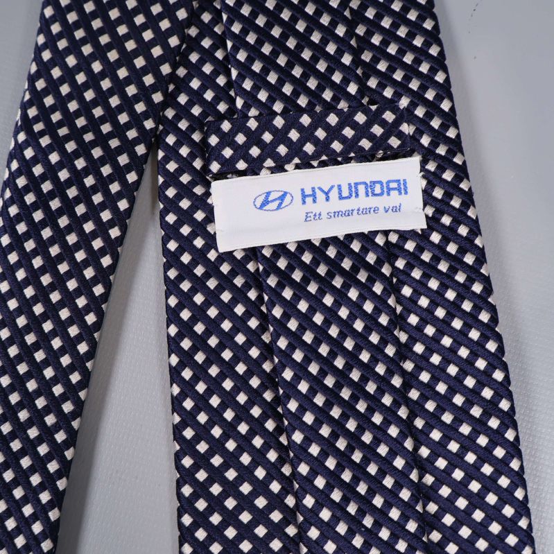 Närbild på Hyundai-etikett på rutmönstrad slips