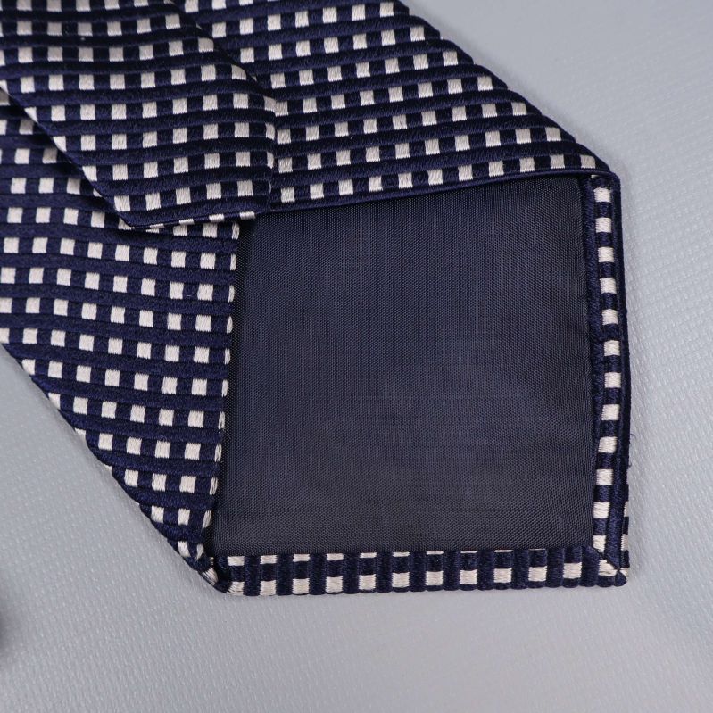 Närbild på slipsens spets och tygdetaljer