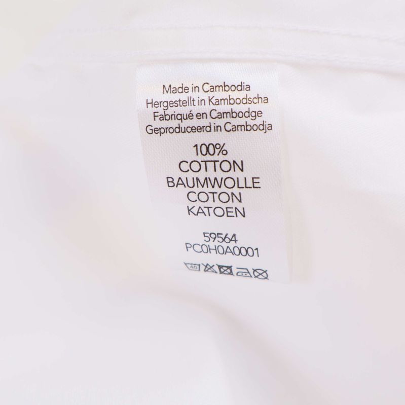 Materialetikett som visar 100% bomull på flera språk