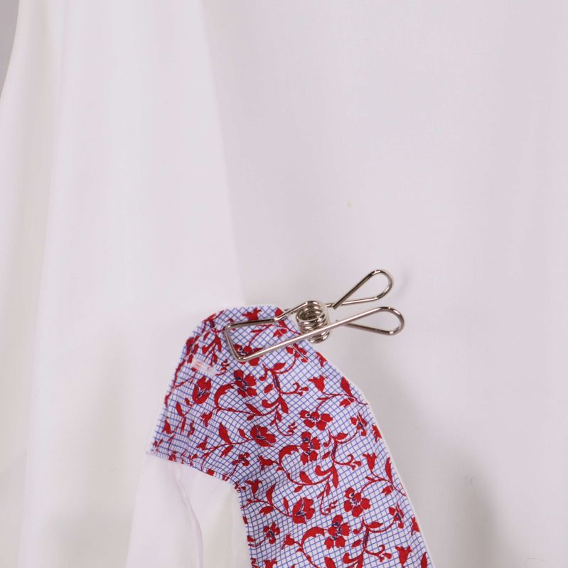 Närbild på tyg i vit skjorta med färgglad insida