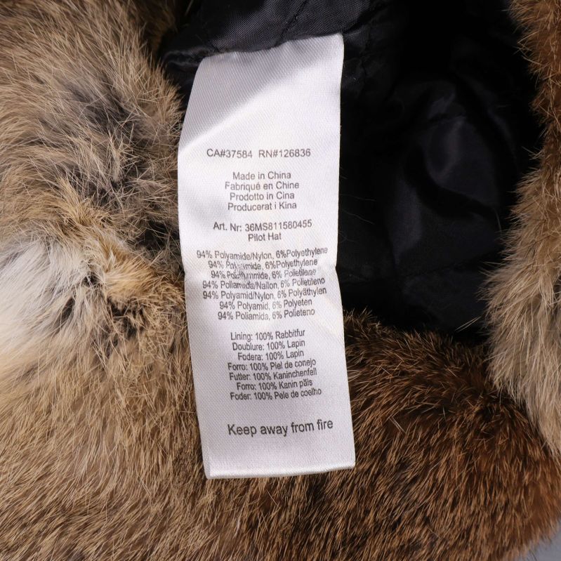 Materiallapp på insidan av svart fuskpälsmössa