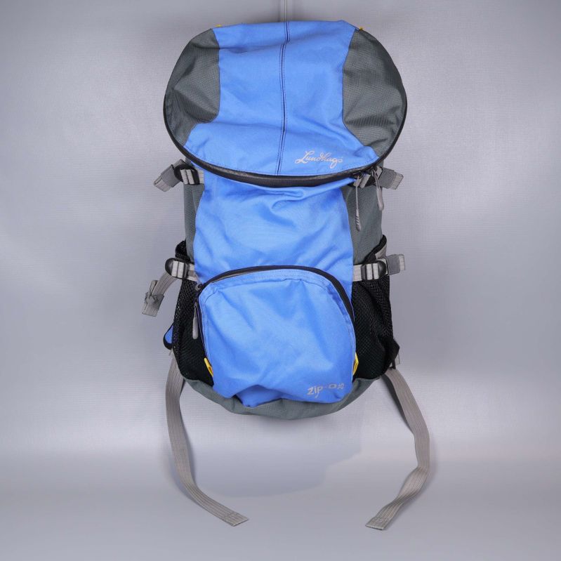 Blå och grå ryggsäck fotad framifrån med lock