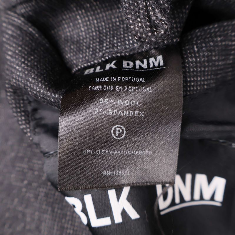 Tvättrådslapp med materialinformation i kavajen