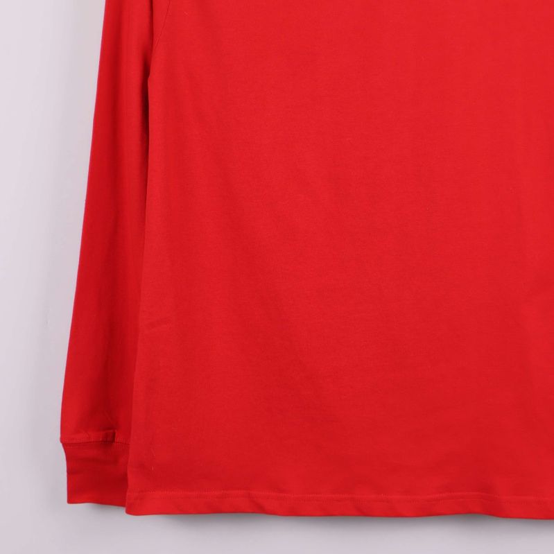 Närbild på nederkant och ärmslut på röd tröja