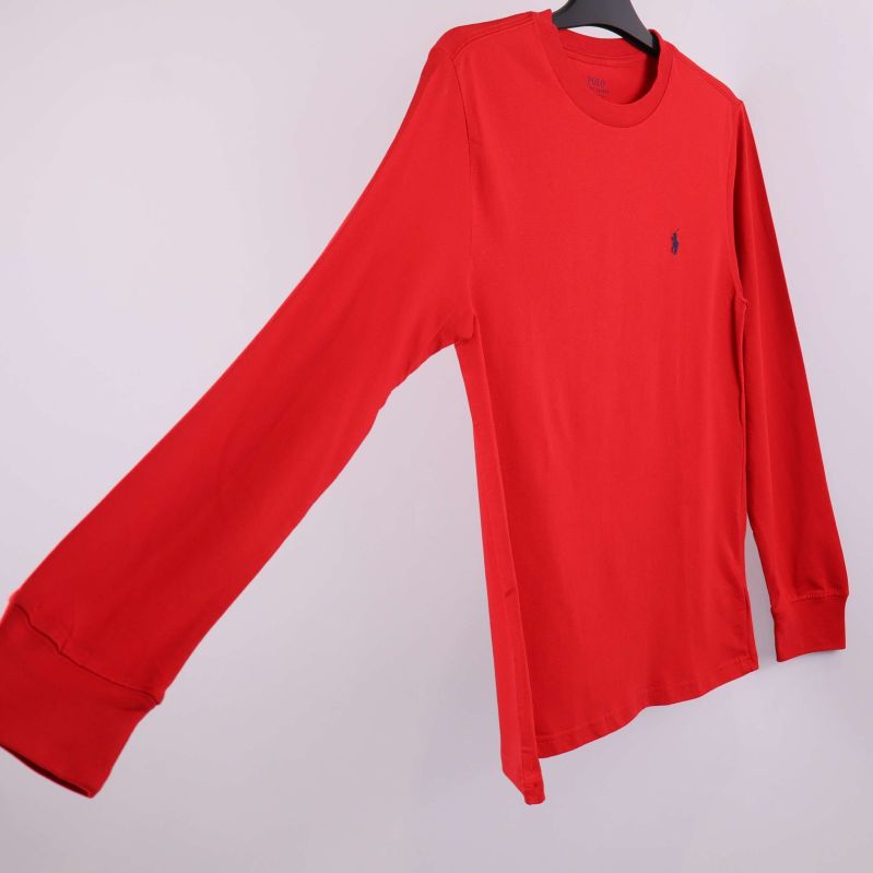 Röd tröja med lång ärm utsträckt åt sidan