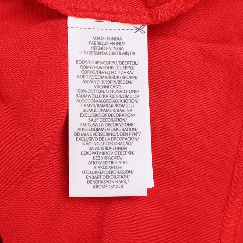 Materiallapp visar 100 procent bomull på röd tröja