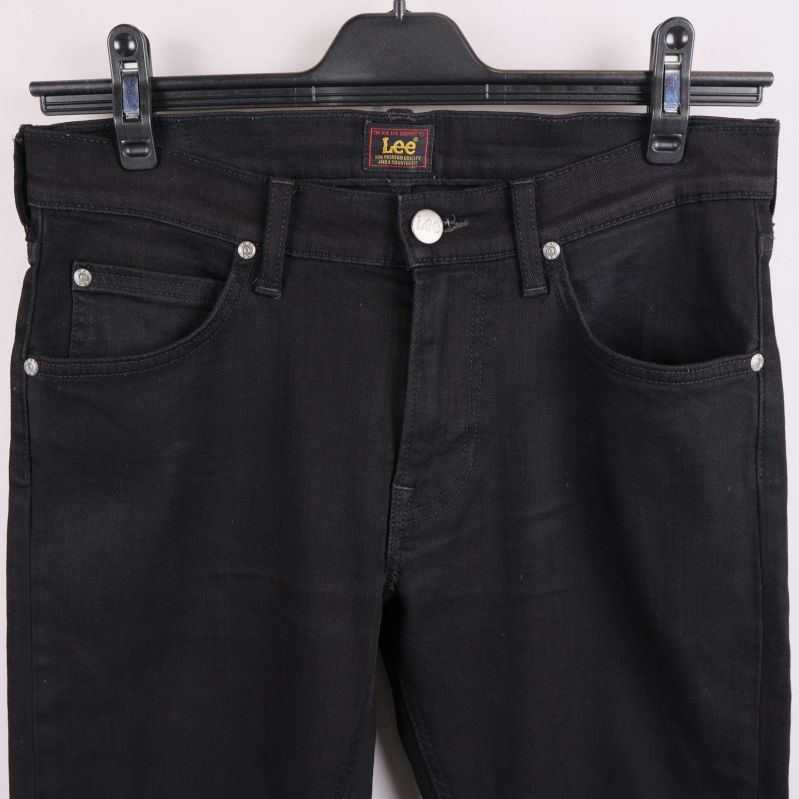 Närbild på framfickor, knapp och dragkedja på svarta jeans