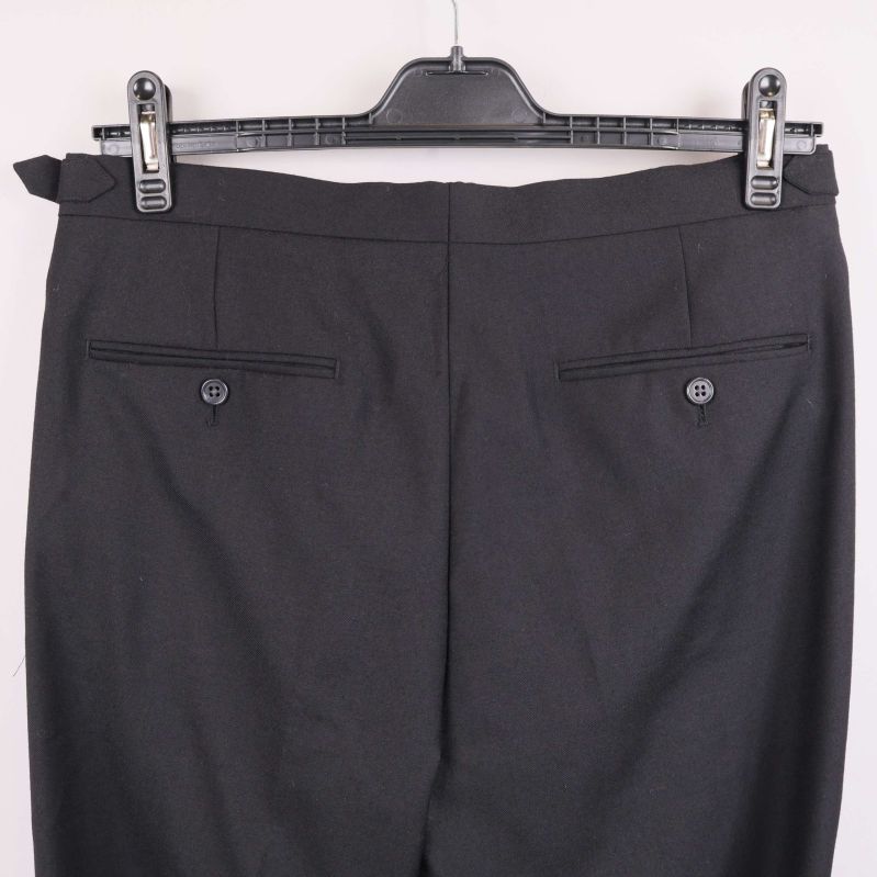 Närbild på bakfickor med knappar på byxa