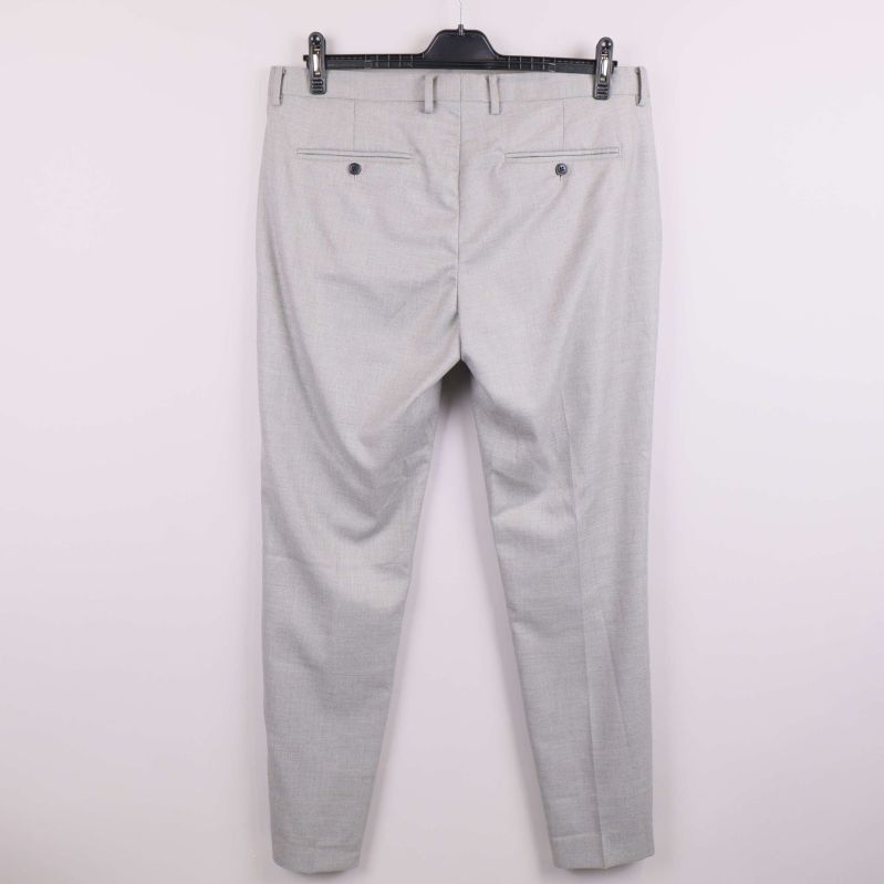 Baksidan av ljusgrå kostymbyxa med knäppning på bakfickor