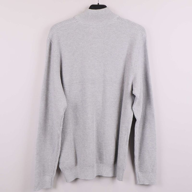 Grå stickad tröja visad bakifrån på galge