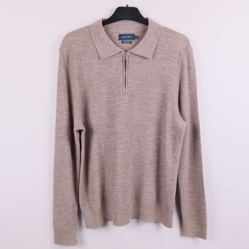 Beige stickad tröja med dragkedja och krage på galge