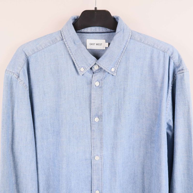 Närbild på skjortans krage och övre knappdel