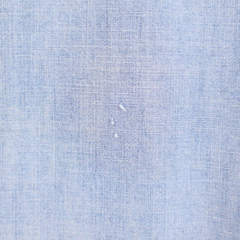 Närbild på mindre skador på skjortans rygg