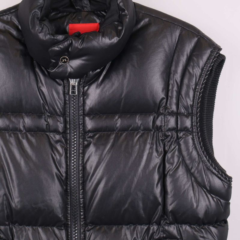 Detaljbild på axel och krage av svart dunväst